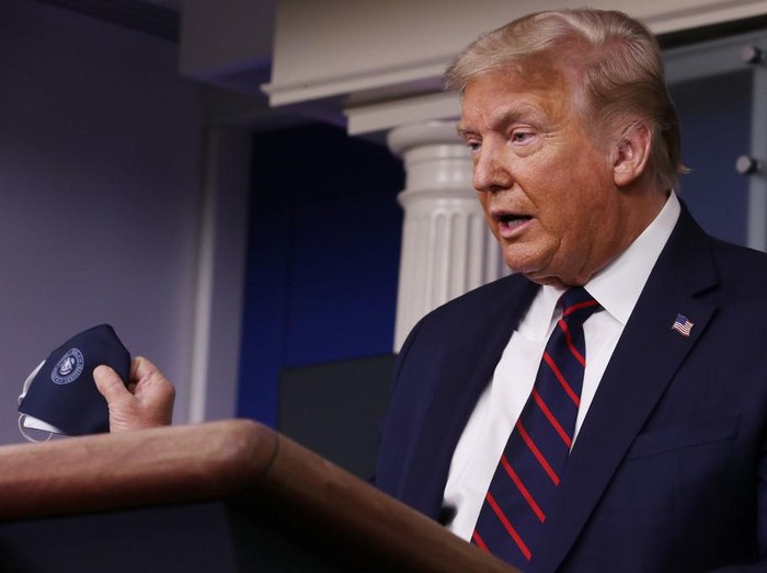 WASHINGTON, DC - JULY 21: U.S. President Donald Trump talks to holds up his face mask during a press conference in the Brady Press Briefing Room at the White House July 21, 2020 in Washington, DC. Trump focused on his administrations handling of the global coronavirus pandemic. Poll numbers about his handling of COVID-19 have been falling as cases of deadly virus have spiked across the country.   Chip Somodevilla/Getty Images/AFP