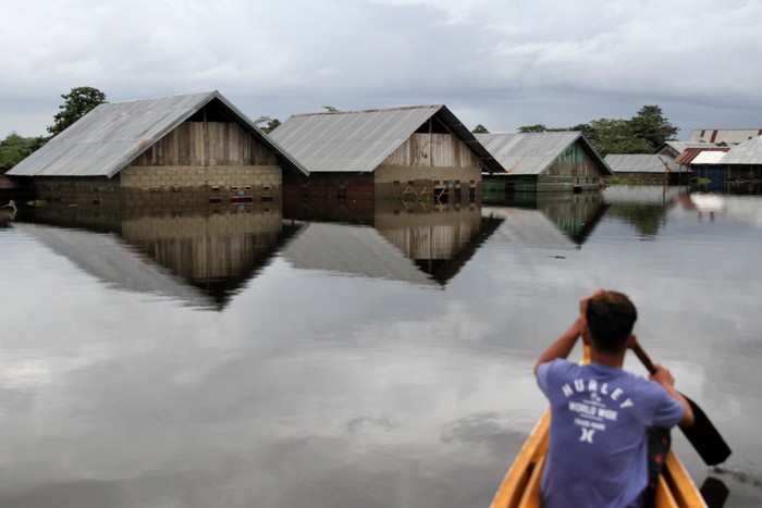 KETINGGIAN BANJIR MENCAPAI 4 METER Warga menggunakan rakit melintasi rumah yang terendam banjir di Desa Laloika, Kecamatan Pondidaha, Kabupaten Konawe, Sulawesi Tenggara, Rabu (22/7/2020). Banjir akibat luapan Sungai Konaweha dan Sungai Lahambuti yang merendam di tiga Desa Laloika, Wonuamonapa dan Desa Lalonggotomi mencapai ketinggian empat meter. ANTARA FOTO/Jojon/foc.