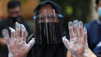 Pemilih juga memakai sarung tangan plastik saat akan melakukan pencoblosan di bilik suara.