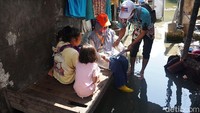 Petugas melakukan pendataan di tengah banjir rob di Desa Purworejo, Kecamatan Bonang, Demak.