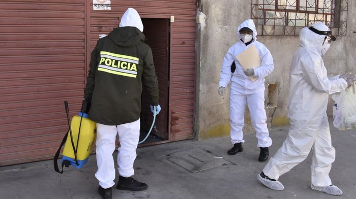 Health workers and police officers in protective suits carry out an epidemiological evaluation at the houses of police officers to detect possible infections of the novel coronavirus, COVID-19, in El Alto, Bolivia, on July 18, 2020. - The pandemic has killed at least 596,742 people worldwide since it surfaced in China late last year and more than 14 million have been infected, according to an AFP tally at 1100 GMT on Saturday based on official sources. (Photo by Aizar RALDES / AFP)