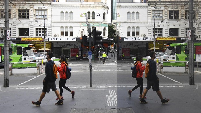 People wearing face masks to help protect against the spread of the new coronavirus walk in the central business district in Melbourne, Australia, Wednesday, July 22, 2020. Australia’s hard-hit Victoria state reported a record new COVID-19 cases on Wednesday and health authorities warned that numbers could continue to rise. With Australia’s second-largest city Melbourne now in lockdown for two weeks, authorities had hoped the infection rate would begin to plateau. (James Ross/AAP Image via AP)