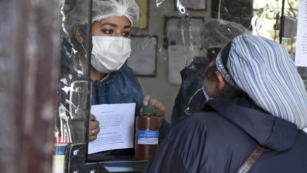 Warga membeli botol klorin dioksida di apotek di Cochabamba, Bolivia, Jumat, 17 Juli 2020. Warga rela mengntre  setiap pagi di Cochabamba untuk membeli botol kecil klorin dioksida, zat pemutih yang dianggap sebagai obat untuk COVID-19 dan berbagai penyakit lainnya. (Foto AP / Dico Solis)