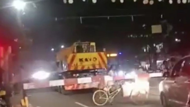 Crane Mogok di Jalan Crane mogok di tengah rel saat kereta api akan lewat.