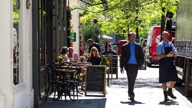Ilustrasi Kedai Teh London, UK - 21 May, 2019: color image depicting people sitting at tables, eating and drinking outside a posh cake shop/cafe in the Belgravia area of London, UK. The exterior of the shop is decorated with beautiful garlands of fresh flowers. It is a beautiful day with bright blue sky. Room for copy space.