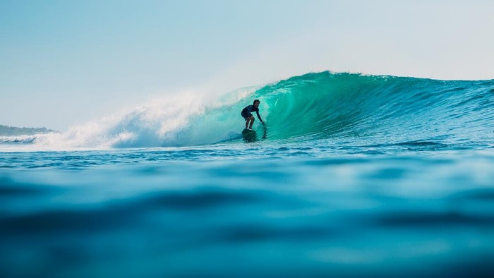 January 16, 2020. Bali, Indonesia. Surfer ride on ocean wave. Professional surfing in ocean at waves