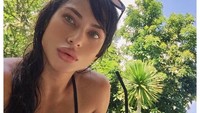 Begini pesona Monica saat liburan di Bali. Ia menikmati segelas minuman segar usai berenang. Foto: Instagram monicasinatra
