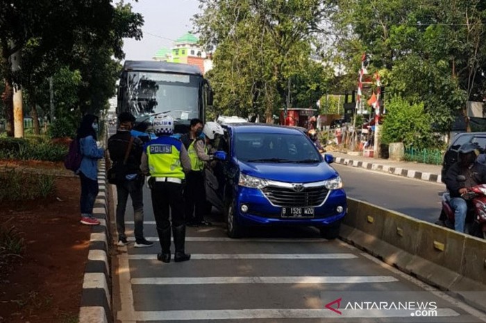 Petugas Satlantas Polrestro Jakarta Timur menindak pelanggar aturan lalulintas karena masuk jalur TransJakarta dalam Operasi Patuh Jaya 2020 di Jalan Mayjen Sutoyo, Kamis (23/7/2020).