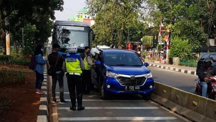 Petugas Satlantas Polrestro Jakarta Timur menindak pelanggar aturan lalulintas karena masuk jalur TransJakarta dalam Operasi Patuh Jaya 2020 di Jalan Mayjen Sutoyo, Kamis (23/7/2020).