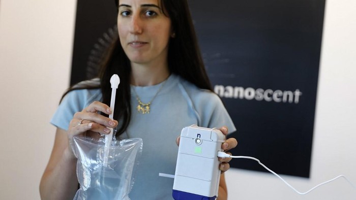 An employee holds a coronavirus breathalyser test at the laboratory of NanoScents headquarters in Misgav industrial zone near the northern Israeli city of Karmiel, on July 21, 2020. - An Israeli company is developing a coronavirus breathalyser test that gives results in 30 seconds, billing it as a 