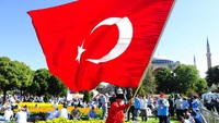 Sebagian jemaah datang dengan membawa bendera Turki. AP / Yasin Akgul.