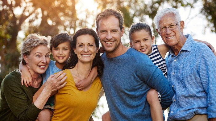 Portrait of a family with two young children posing together outside