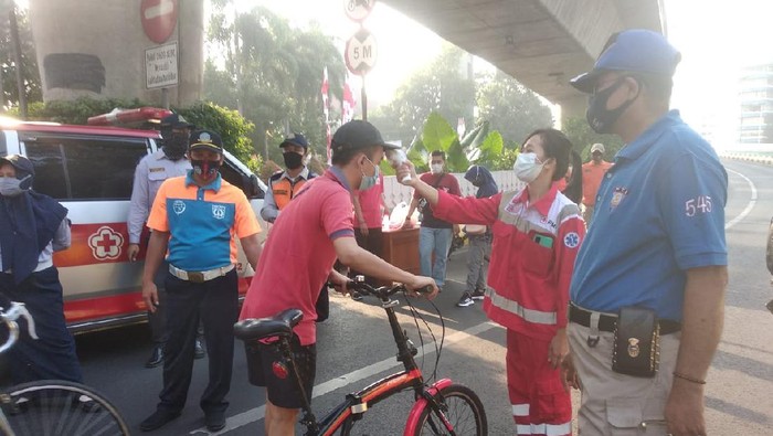 Pengecekan suhu tubuh sebelum memasuki kawasan CFD JLNT Antasari, Jakarta Selatan, Minggu (26/7/2020) pagi.