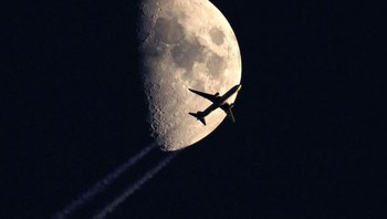 Pesawat yang terlihat terbang di bawah bulan. Foto: Brightside