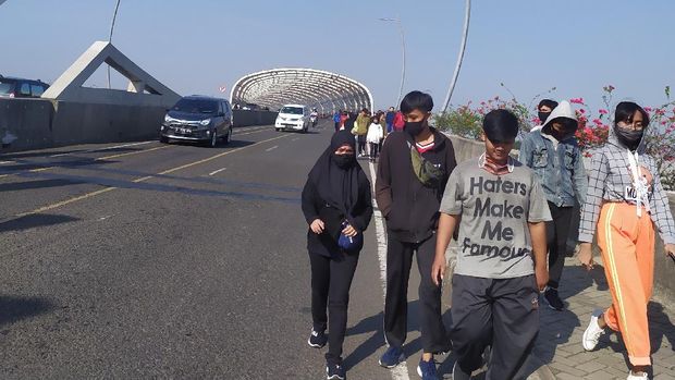 Warga masih berjalan di pinggir Flyover Summarecon Bekasi meski waktu CFD telah berakhir, Minggu (26/7/2020).