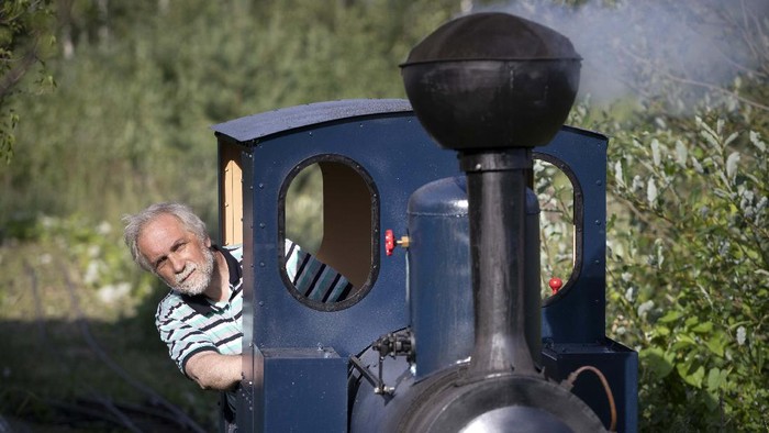 A miniature steam train runs across a bridge on Pavel Chilin's miniature personal narrow-gauge railway twisting through the grounds of his home in Ulyanovka village outside St. Petersburg, Russia Sunday, July 19, 2020. It took Chilin more than 10 years to build the 350-meter-long mini-railway complete with various branches, dead ends, circuit loops, and even three bridges.(AP Photo/Dmitri Lovetsky)
