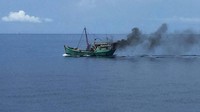 Saat hendak diperiksa kapal Vietnam itu melarikan diri disertai melepas jaring ikan berwarna hitam untuk menghilangkan barang bukti dan membakar ban di buritan menyebabkan asap hitam mengebul di udara. (dok. Bakamla)