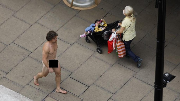 BRITAIN-HEALTH-VIRUS-MASKS A man wearing a face mask to cover his genitals is seen walking along Oxford Street in London on July 24, 2020, after wearing facemasks in shops and supermarkets became compulsory in England as a measure to combat the spread of the novel coronavirus. - (Photo by Tolga AKMEN / AFP)