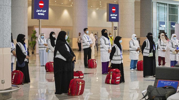 Policemen wearing gloves and face masks to help prevent the spread of the coronavirus, provide security for pilgrims, in Mecca, Saudi Arabia, Sunday, July 26, 2020. Only about 1,000 pilgrims will be allowed to perform the annual hajj pilgrimage that begins later this month due to the virus pandemic. (Saudi Ministry of Media via AP)