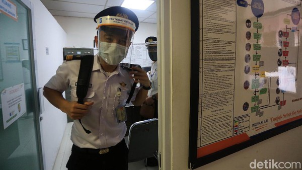 Dengan berseragam lengkap serta memakai masker dan face shield, seorang masinis bergegas menuju kereta untuk mengoperasikan kereta sesuai tujuan. Dengan berseragam lengkap serta memakai masker dan face shield, seorang masinis bergegas menuju kereta untuk mengoperasikan kereta sesuai tujuan.