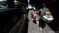 Seorang pedagang tengah menawarkan pernak-pernik HUT Kemerdekaan RI kepada pengendara.