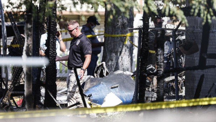 Police officers investigate a plane crash near Old Bingham Highway in West Jordan, Utah, on Saturday, July 25, 2020. (Yukai Peng/The Deseret News via AP)