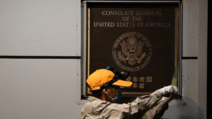 A worker attempts to remove the wall insignia of the US Consulate in Chengdu, southwestern Chinas Sichuan province, on July 26, 2020. - Workers removed the US insignia from the consulate in the Chinese city of Chengdu on July 26, one day after Beijing ordered its closure as relations deteriorated in a Cold War-style standoff. (Photo by Noel Celis / AFP)