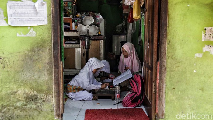 Sejumlah anak-anak melakukan kegiatan belajar di rumah di kawasan Gang Bebek, Kalibaru, Cilincing, Jakarta Utara, Senin (27/7). Menurut keterangan warga, saat ini anak-anak telah melakukan kegiatan belajar dirumah sejak pandemi COVID-19 mulai masuk ke Jakarta sejak bulan Maret.