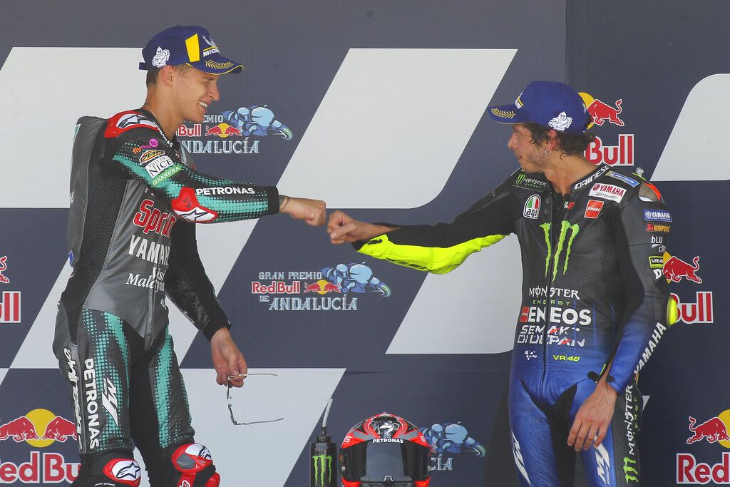 Fabio Quartararo of France, left and Valentino Rossi of Italy touch fists after Quartararo won the race with Rossi finishing 3rd during the MotoGP race during the Andalucia Motorcycle Grand Prix at the Angel Nieto racetrack in Jerez de la Frontera, Spain, Sunday July 26, 2020. (AP Photo/David Clares)