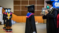 Rektor UNDIP Yos Johan Utama (kanan) menyerahkan ijazah kelulusan kepada robot peraga saat wisuda secara daring di Universitas Diponegoro (UNDIP), Semarang, Jawa Tengah, Senin (27/7/2020).