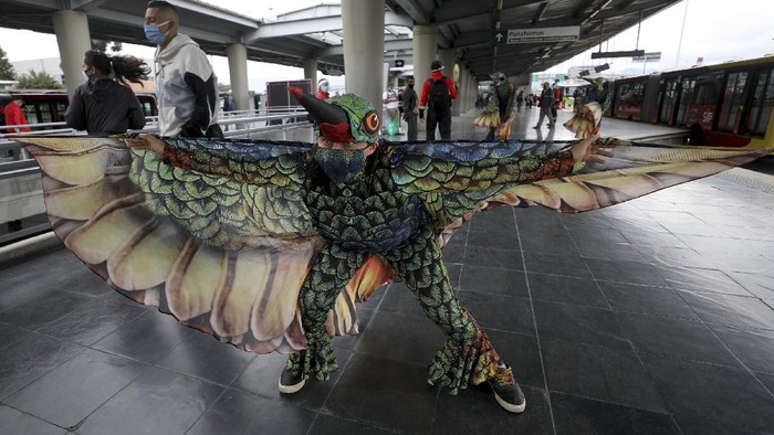 Musicians from Bogota's Youth Philharmonic Orchestra and dancers in hummingbird costumes perform for commuters at a bus stop in Bogota, Colombia, Friday, July 24, 2020. They offered a one-hour concert that they say they hope will serve as a 