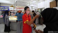Warga yang datang harus menjalani pemeriksaan suhu tubuh.