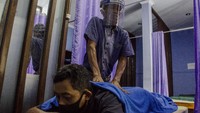 Terapis tunanetra memijat pelanggan dengan menggunakan pelindung wajah di Rumah Bugar Wyata Guna, Bandung, Jawa Barat, Selasa (28/7/2020).