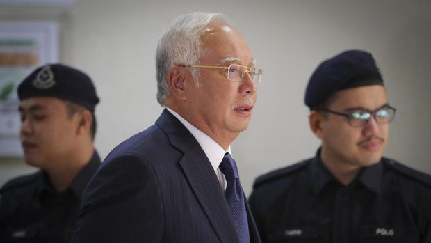 Former Malaysian Prime Minister Najib Razak, center, walks out of a courtroom at Kuala Lumpur High Court in Kuala Lumpur, Malaysia, on Feb. 12, 2019. Najib was found guilty Tuesday, July 28, 2020 in his first corruption trial linked to one of the world’s biggest financial scandals - the billion-dollar looting of the 1MDB state investment fund. (AP Photo/Vincent Thian)