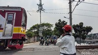 Warga mengatur lalu-lintas di perlintasan kereta api tanpa palang pintu, di Jl Kembangan Baru, Jakarta Barat, Selasa (28/7/2020).