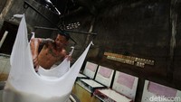 Bubur kedelai disaring menggunakan kain untuk memisahkan sari dengan ampasnya.