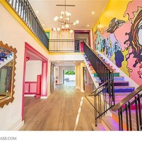 Rumah dua lantai ini dihubungkan dengan anak tangga warna-warni. Pada salah satu bagian dindingnya terdapat lukisan mural, juga dikreaskan dengan cat beraneka warna. Foto: Compass.com