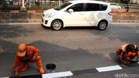 Sejumlah petugas dikerahkan untuk melakukan pengecetan sisi trotoar di kawasan Simprug, Jakarta Selatan, tersebut.