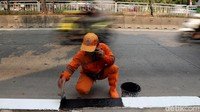 Sejumlah Petugas Penanganan Prasarana dan Sarana Umum (PPSU) Kelurahan Grogol Selatan mengecat trotoar di Jalan Teuku Nyak Arief, Simprug, Jakarta Selatan, Rabu (29/7/2020).