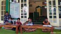 Mereka berada di serambi masjid tersebut memanfaatkan WiFi gratis di masjid itu untuk belajar online.