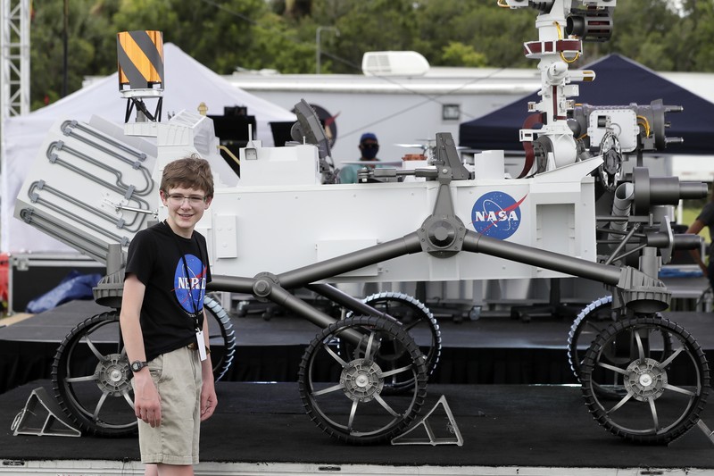 Alexander Mather, of Burke, Va. stands next to a model of the Mars 2020 rover he named in a contest during a news conference at the Kennedy Space Center Tuesday, July 28, 2020, in Cape Canaveral, Fla. Mather, submitted the winning entry in NASA's 
