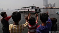 Sejumlah anak-anak melambaikan tangan saat kapal yang berisi hewan-hewan kurban berlayar untuk dikirimkan ke Pulau Seribu jelang Idul Adha.