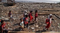 Di sisi lain Sekolah Merah Putih melakukan kegiatan belajar di luar ruangan lepas pantai kawasan Cilincing.