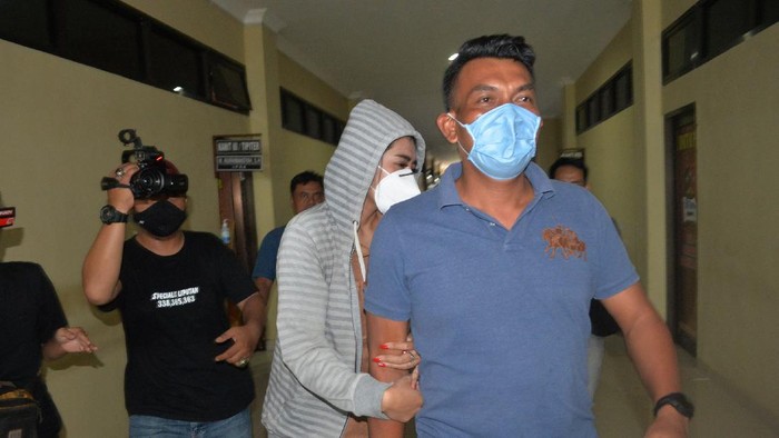 Personel kepolisian membawa artis berinisial VS (tengah) saat akan menjalani pemeriksaan di Polresta Bandar Lampung, Lampung, Rabu (29/7/2020). Vernita Syabilla (VS) yang juga selebgram dan artis Film Televisi (FTV) tersebut ditangkap Polresta Bandar Lampung dari sebuah hotel berbintang di Bandar Lampung karena diduga terlibat dalam kasus prostitusi. ANTARA FOTO/ Ardiansyah/aww.