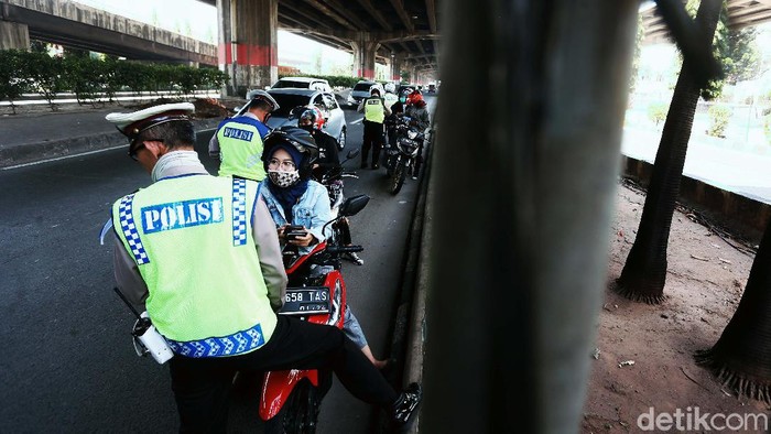 Polisi menggelar Operasi Patuh Jaya 2020, di Jalan DI Pandjaitan, By Pass, Jakarta Timur.  Mereka menindak pemotor yang memasuki jalur cepat.