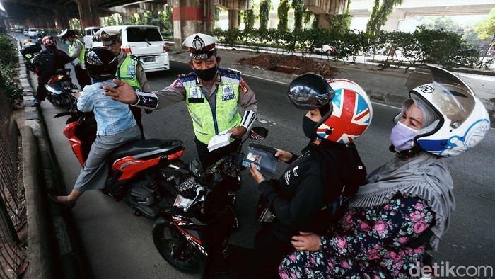 Polisi menggelar Operasi Patuh Jaya 2020, di Jalan DI Pandjaitan, By Pass, Jakarta Timur.  Mereka menindak pemotor yang memasuki jalur cepat.