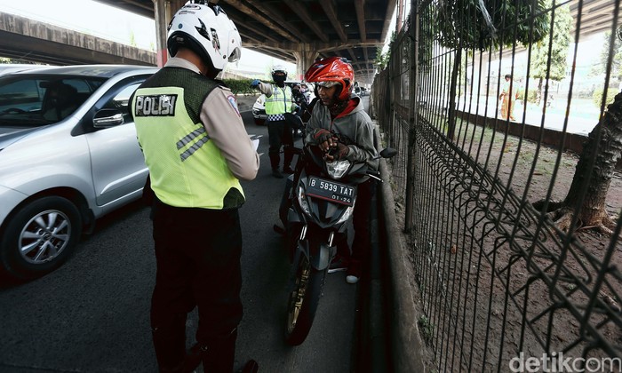 Polisi menggelar Operasi Patuh Jaya 2020, di Jalan DI Pandjaitan, By Pass, Jakarta Timur.  Mereka menindak pemotor yang memasuki jalur cepat.