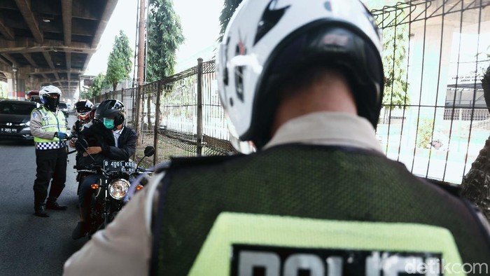 Polisi menggelar Operasi Patuh Jaya 2020, di Jalan DI Pandjaitan, By Pass, Jakarta Timur.  Mereka menindak pemotor yang memasuki jalur cepat.
