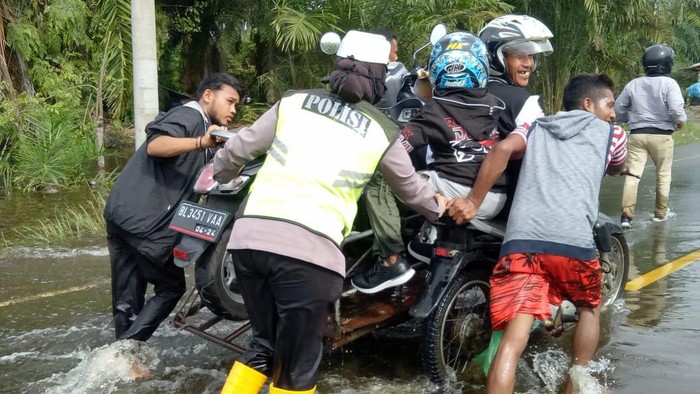 Sepeda motor diangkut becak karena banjir di Aceh Jaya.