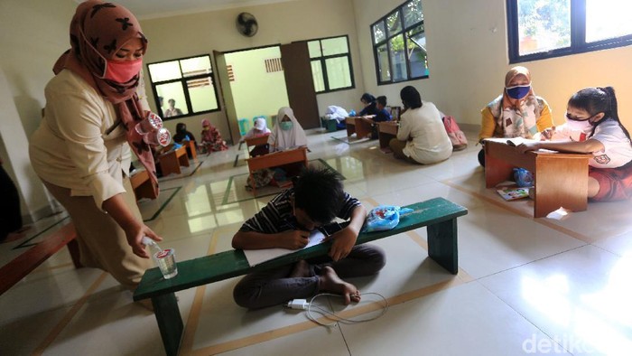 Anak-anak belajar di Aula Kelurahan Jati Rahayu, Kota Bekasi, Jawa Barat, Rabu (29/7/2020). Pihak kelurahan menyediakan fasilitas ruang belajar ber-AC dan wifi gratis bagi siswa. Tujuannya untuk membantu siswa yang selama ini sulit memenuhi paket kuota internet untuk belajar sekolah.